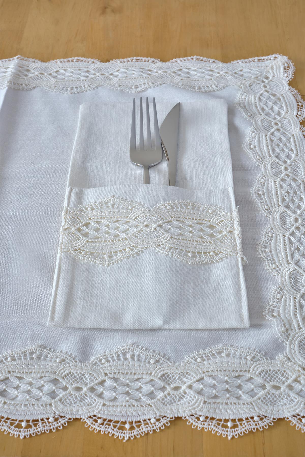 Elegant napkin holder set with fork and knife on a white lace-edged tablecloth