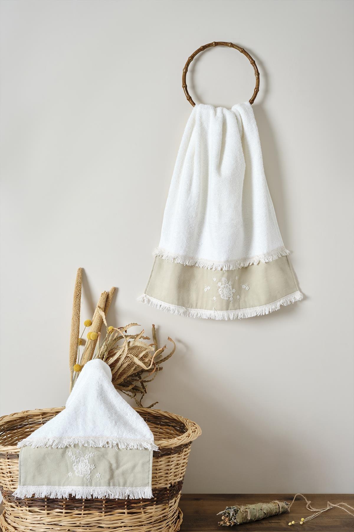 Cream-colored cotton hand towel with lace details, presented with a basket and decorative dried flowers.