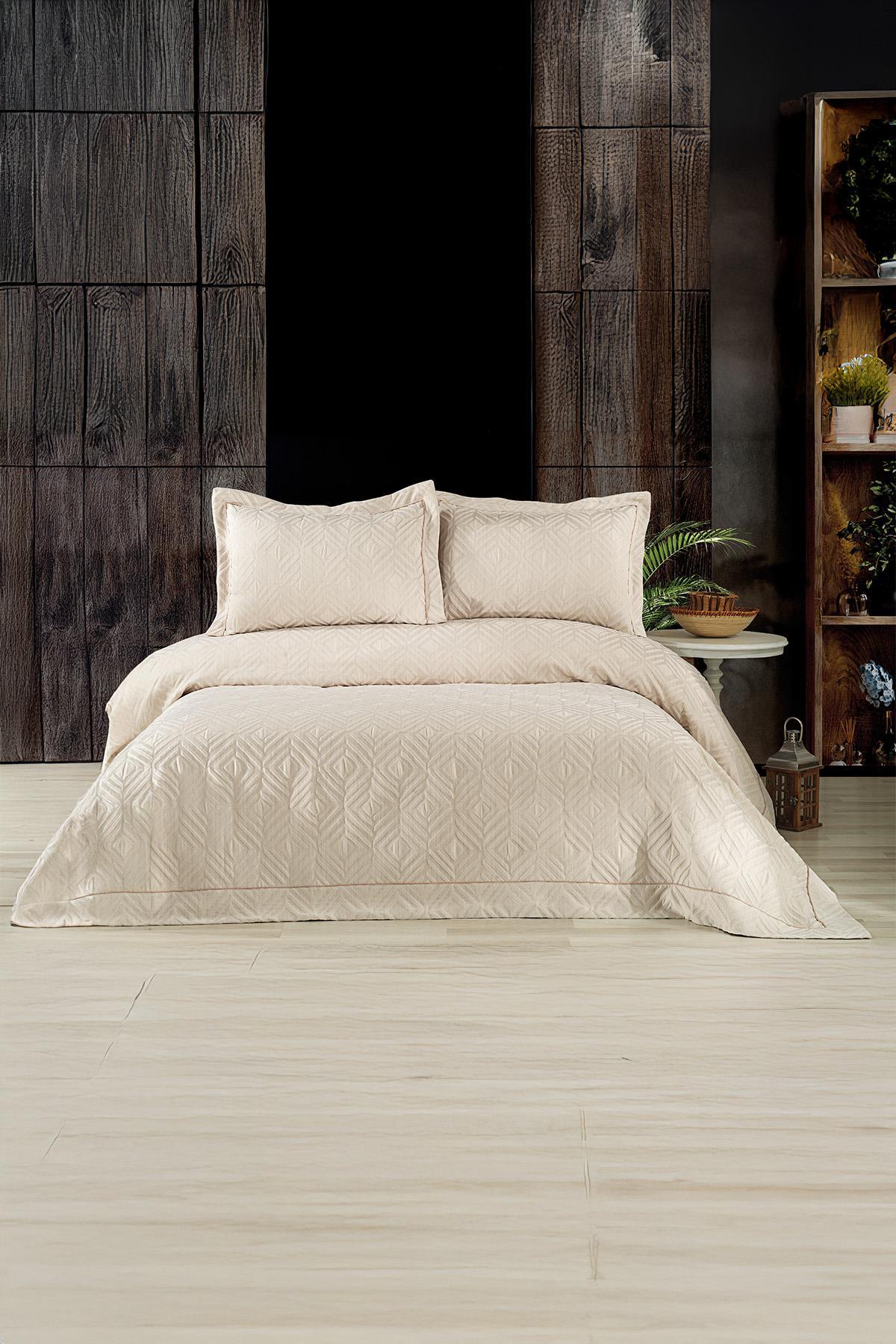 Beige geometric patterned jacquard double bedspread and pillows in a modern bedroom.