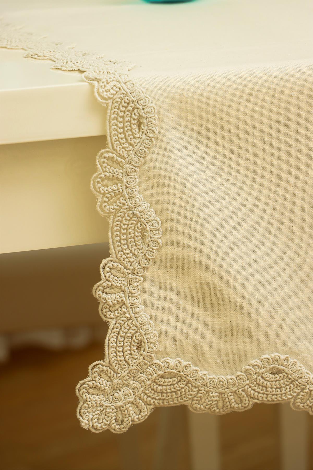 Cream-colored tablecloth with elegant lace edge detailing, modern table decor.