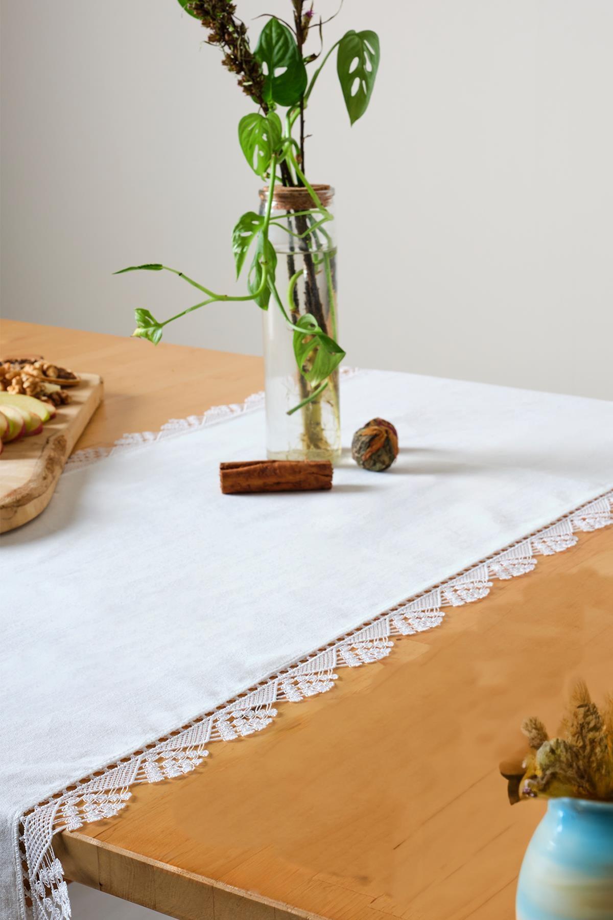 White lace table runner, stylish and elegant decorative look on a wooden table.