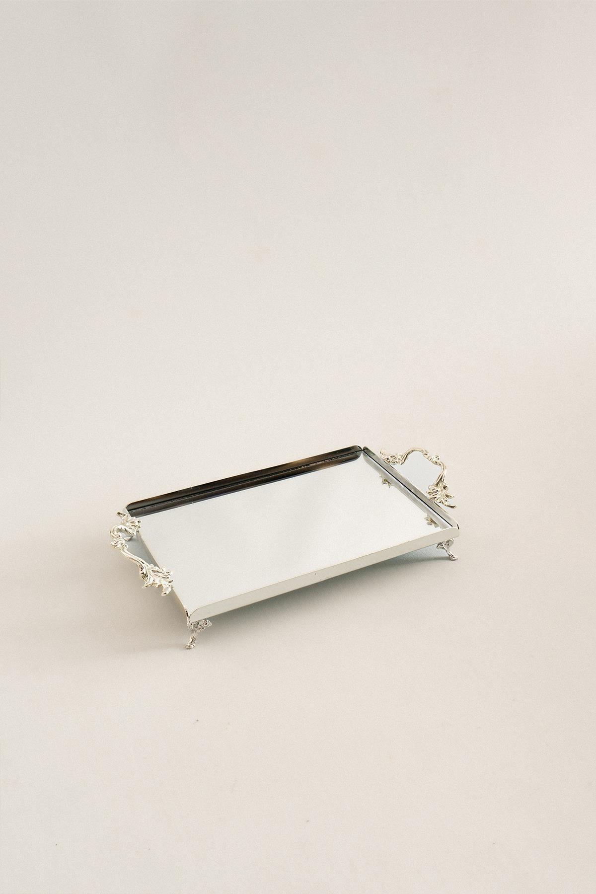 Small rectangular silver tray with elegant handles, mirrored surface, and carved foot details.