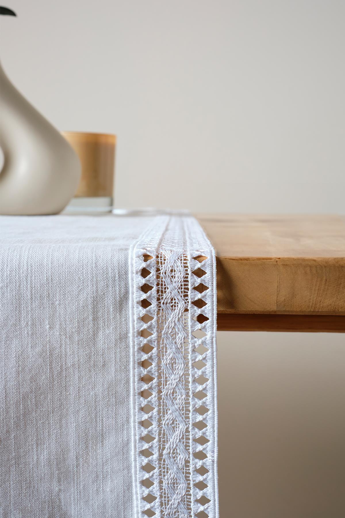 White lace table runner, stylish decorative table cover on a wooden table