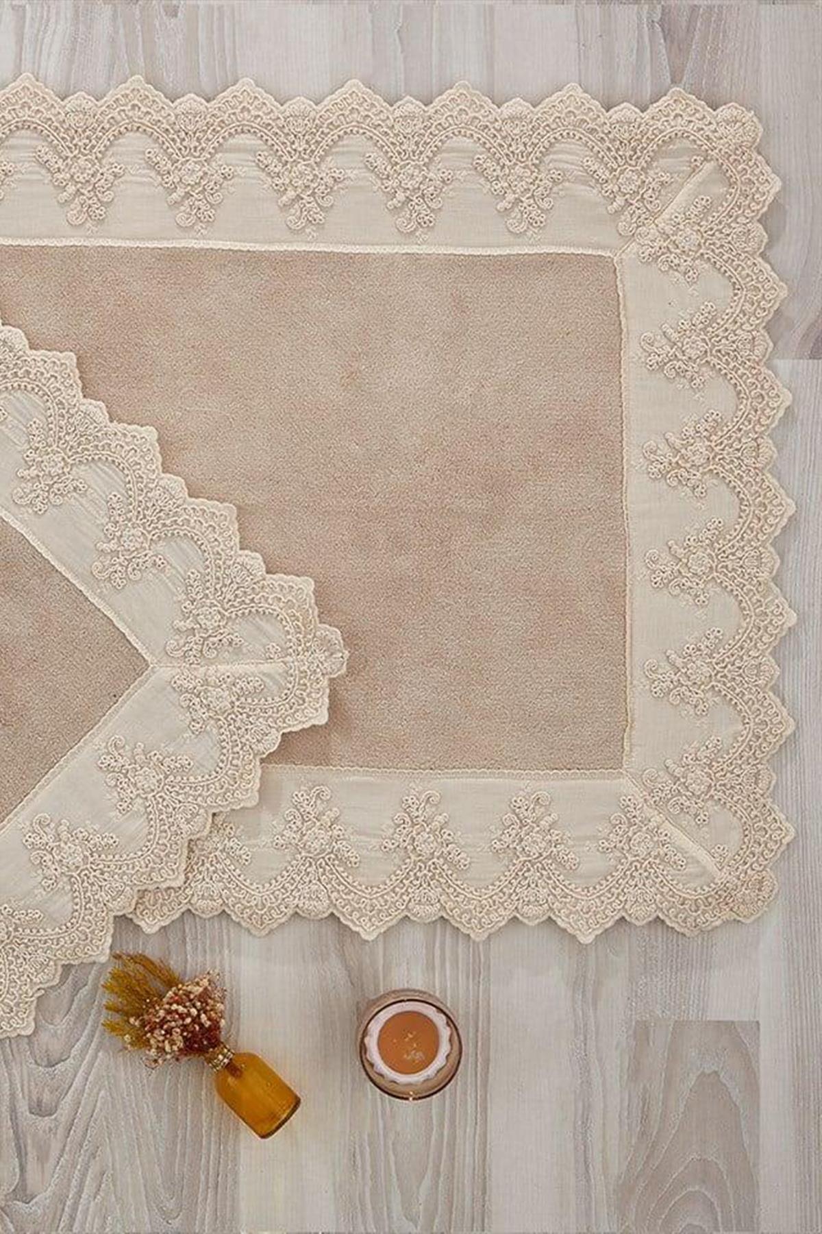 Cream lace-embroidered rectangular 2-piece bath mat set, displayed decoratively on a wooden floor