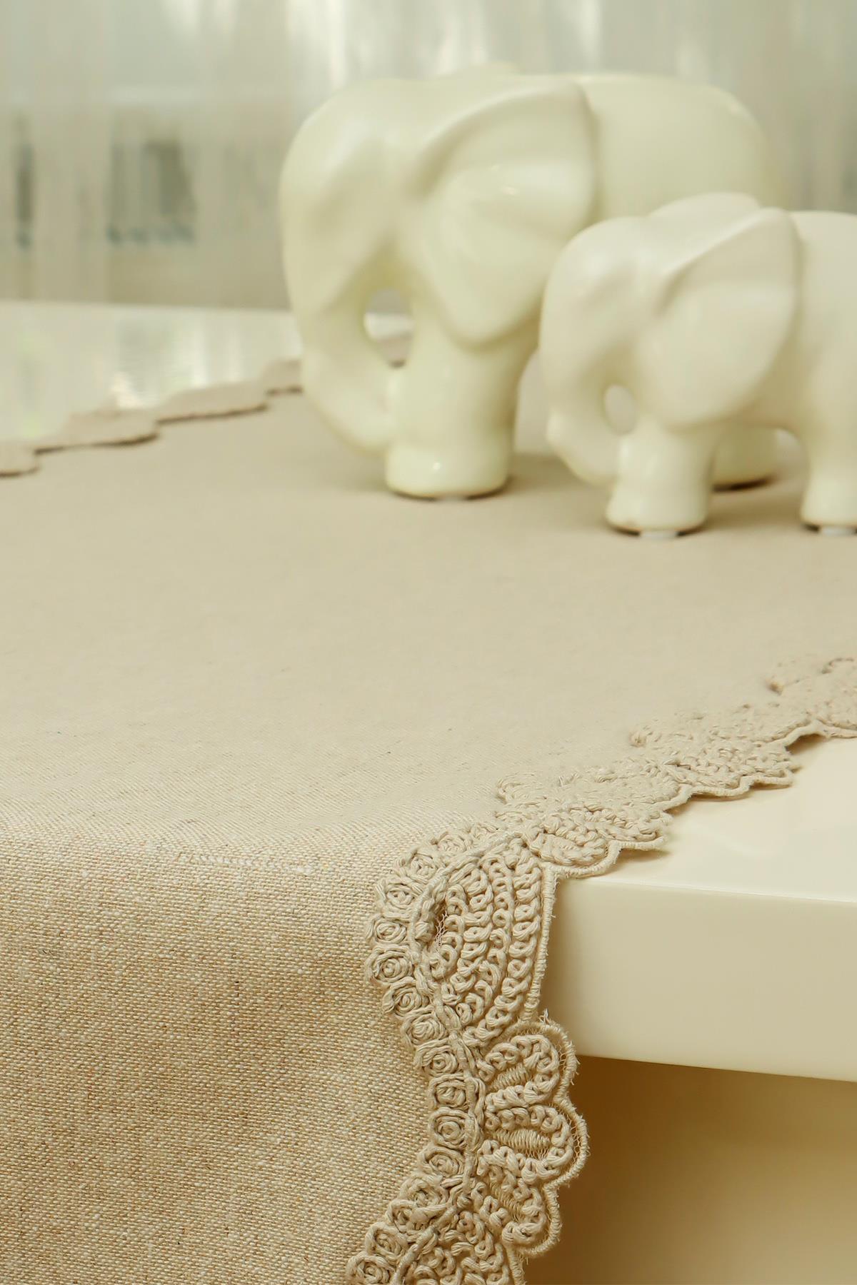 Porcelain elephant figurines on a cream-colored lace-edged tablecloth