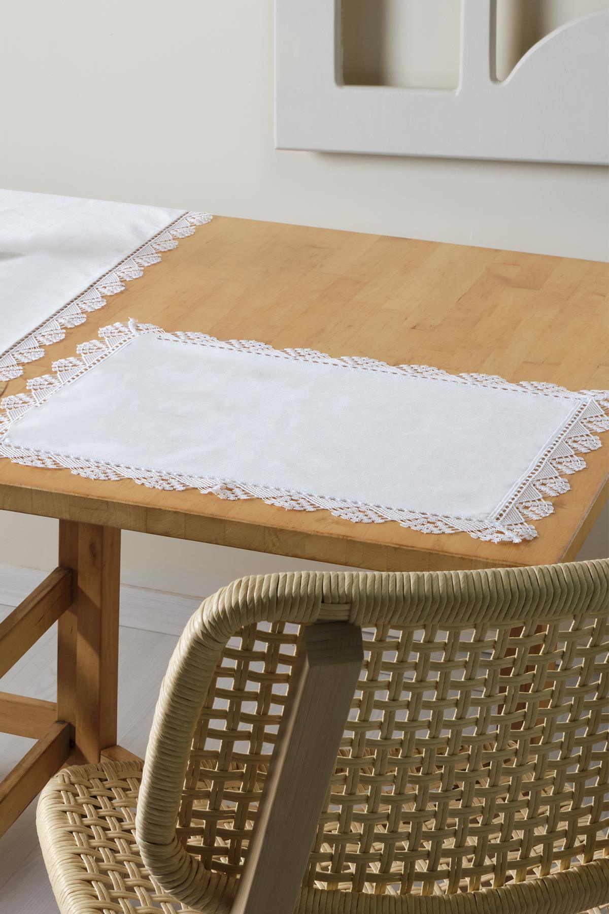 White placemat with lace trim, elegant table decoration on a wooden table